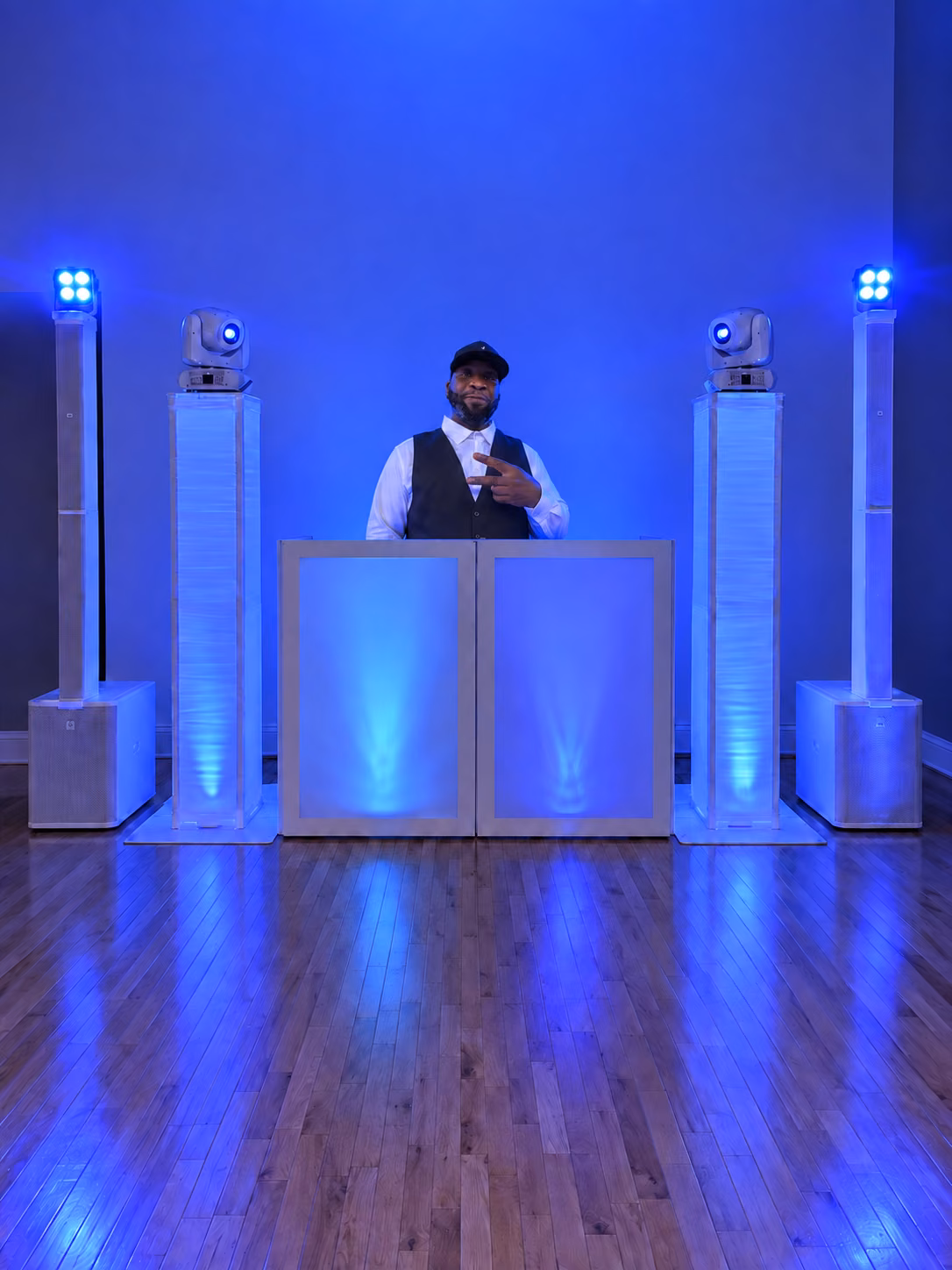 DJ Grizzly behind the white booth in blue light
